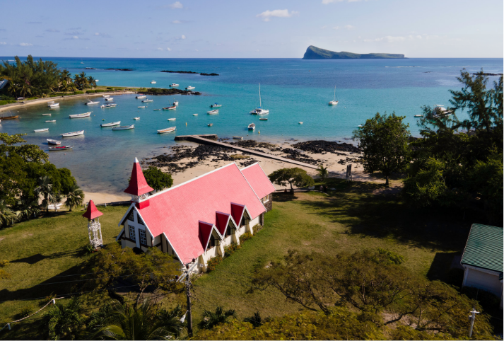 A red-roofed building with a view over the blue ocean in Mauritius.